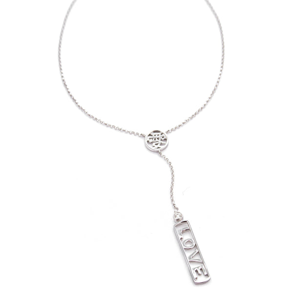 A delicate gold Y-necklace featuring a circular cutout Kanji character for the word love with a short chain segment, and a longer drop charm rectangular bar with the word 'LOVE' and a diamond bezel set diamond.