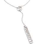 A sterling silver 'Y' necklace featuring a delicate chain with a small circular yin-yang symbol and a dangling rectangular bar with the word 'SERENITY' and a bezel set diamond, shown on a plain white background. 1